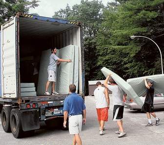 University of New Hampshire students load surplus dorm furniture into an overseas shipping container bound for Haiti at the Durham campus.